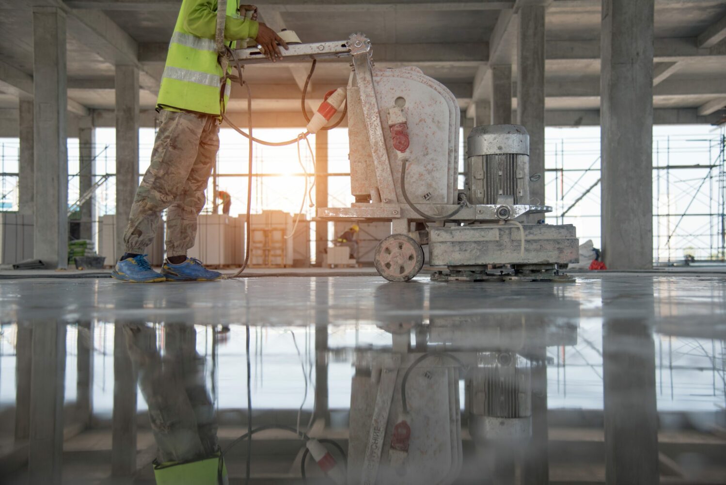 Man grinding concrete in a warehouse