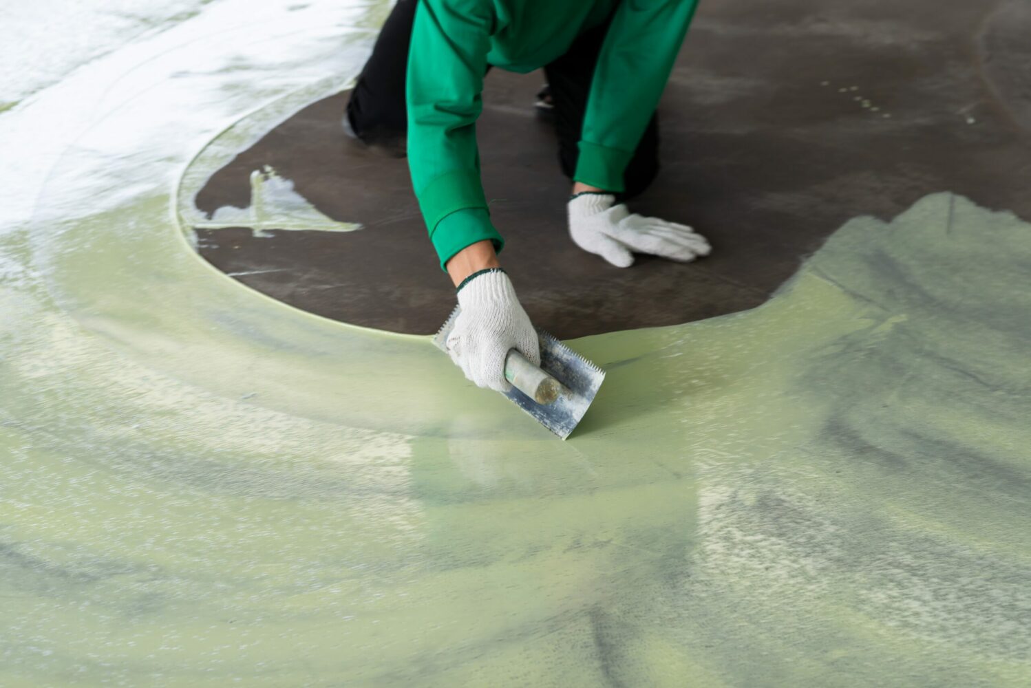 man covering floor in green epoxy layer