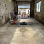 prepping concrete surface for resinous flooring in carwash