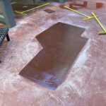 Red urethane cement floor repair in food manufacturing facility