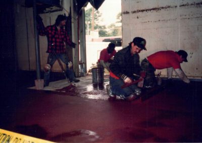Applying red epoxy trowel down flooring in dairy facility